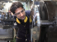 Beschäftigter in Werkstatt an einer Maschine