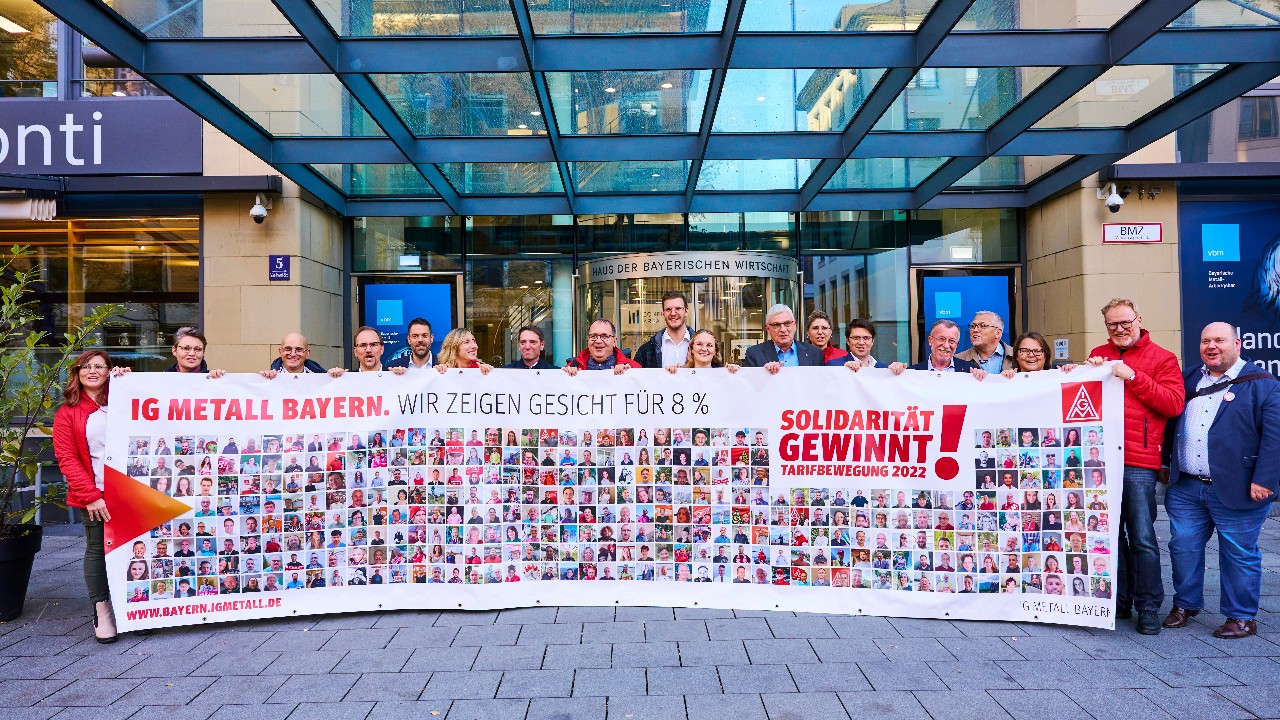 Verhandlungskommission mit Banner Fotoaktion vor vbm-Haus.