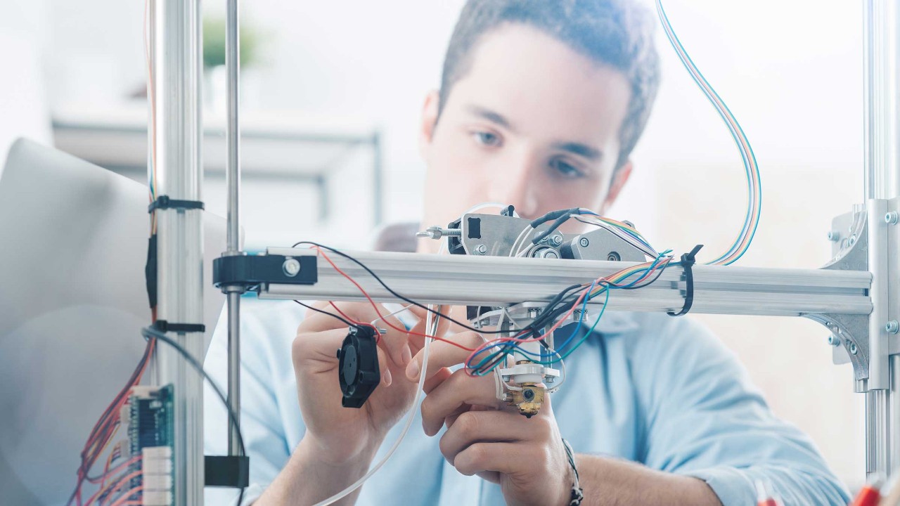 Ein Auszubildender arbeitet an einem 3D-Drucker
